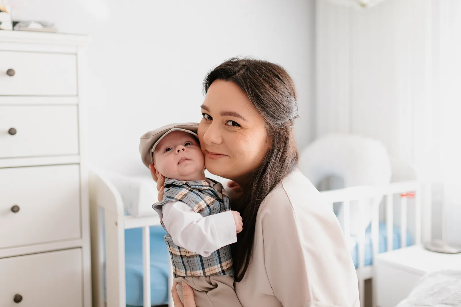 Fotograf na chrzest Nowy Dwór Mazowiecki – mama przytulająca maluszka w domu podczas przygotowań