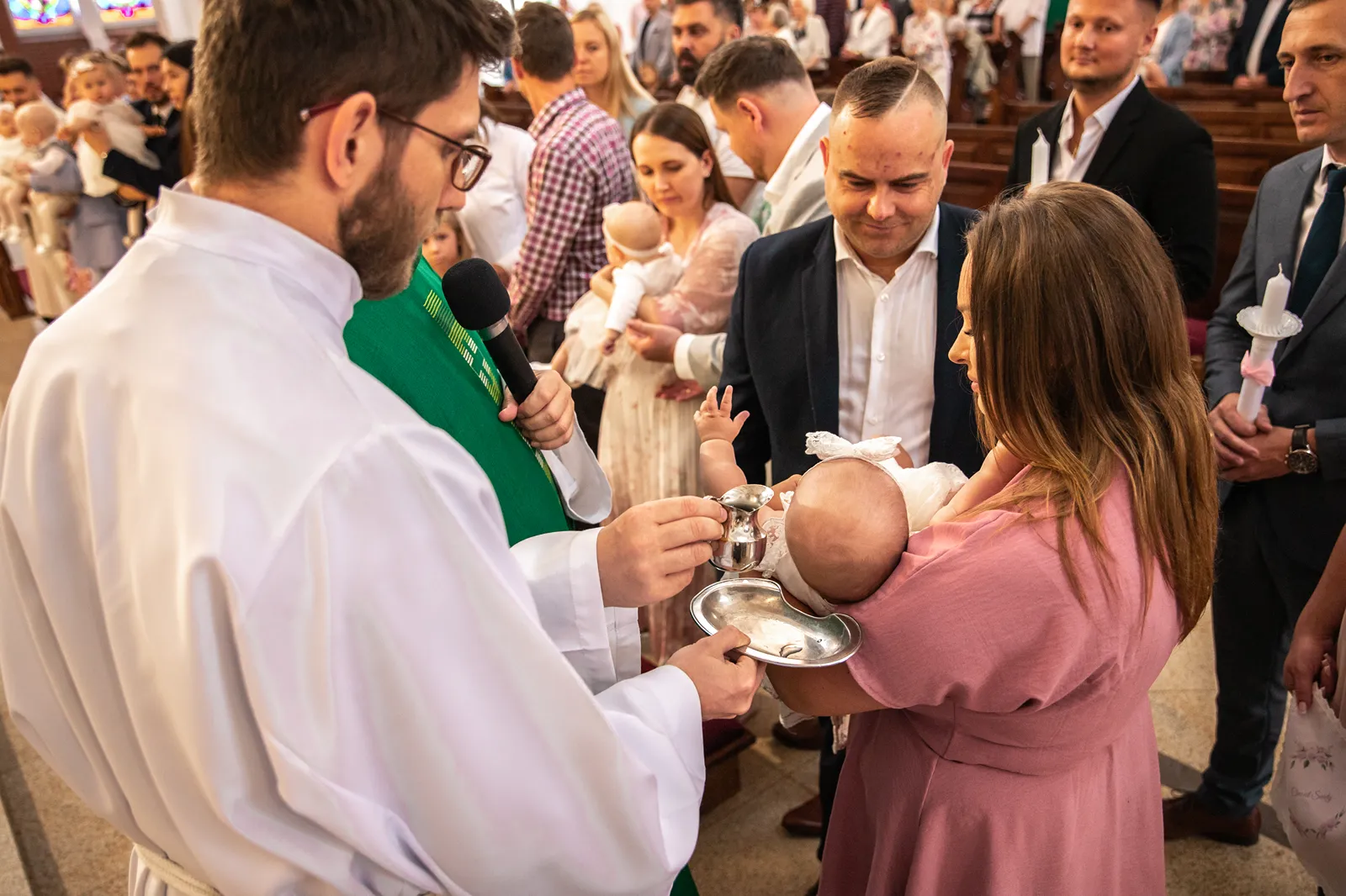 Moment polewania główki dziecka wodą chrzcielną – fotograf na chrzest Nowy Dwór Mazowiecki
