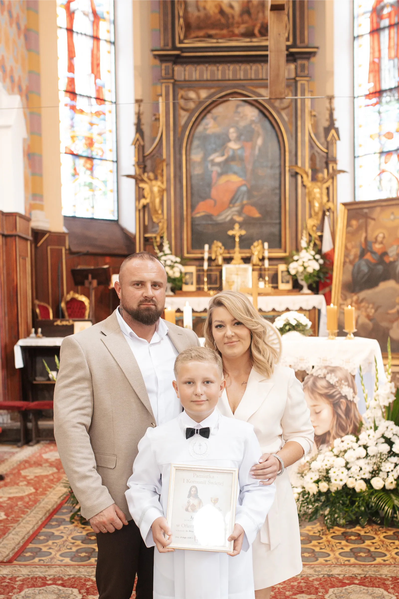 Rodzice z synem w kościele podczas uroczystości Pierwszej Komunii Świętej Legionowo