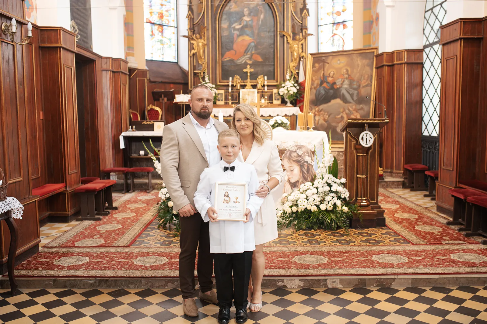 Szerokie ujęcie rodziny w kościele podczas mszy świętej komunijnej Legionowo
