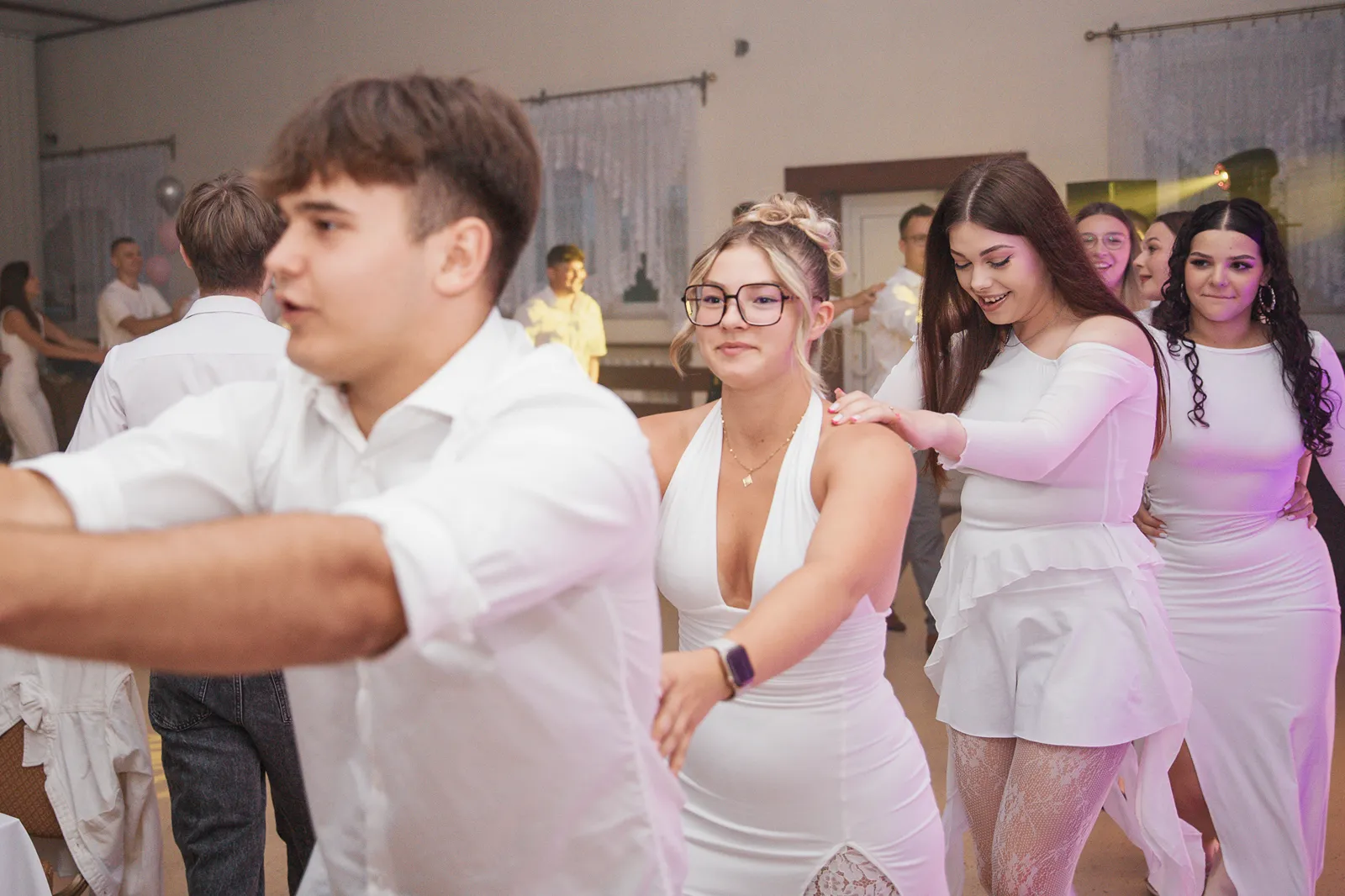 Podrzucanie jubilatki w powietrze przez gości na parkiecie w Legionowie