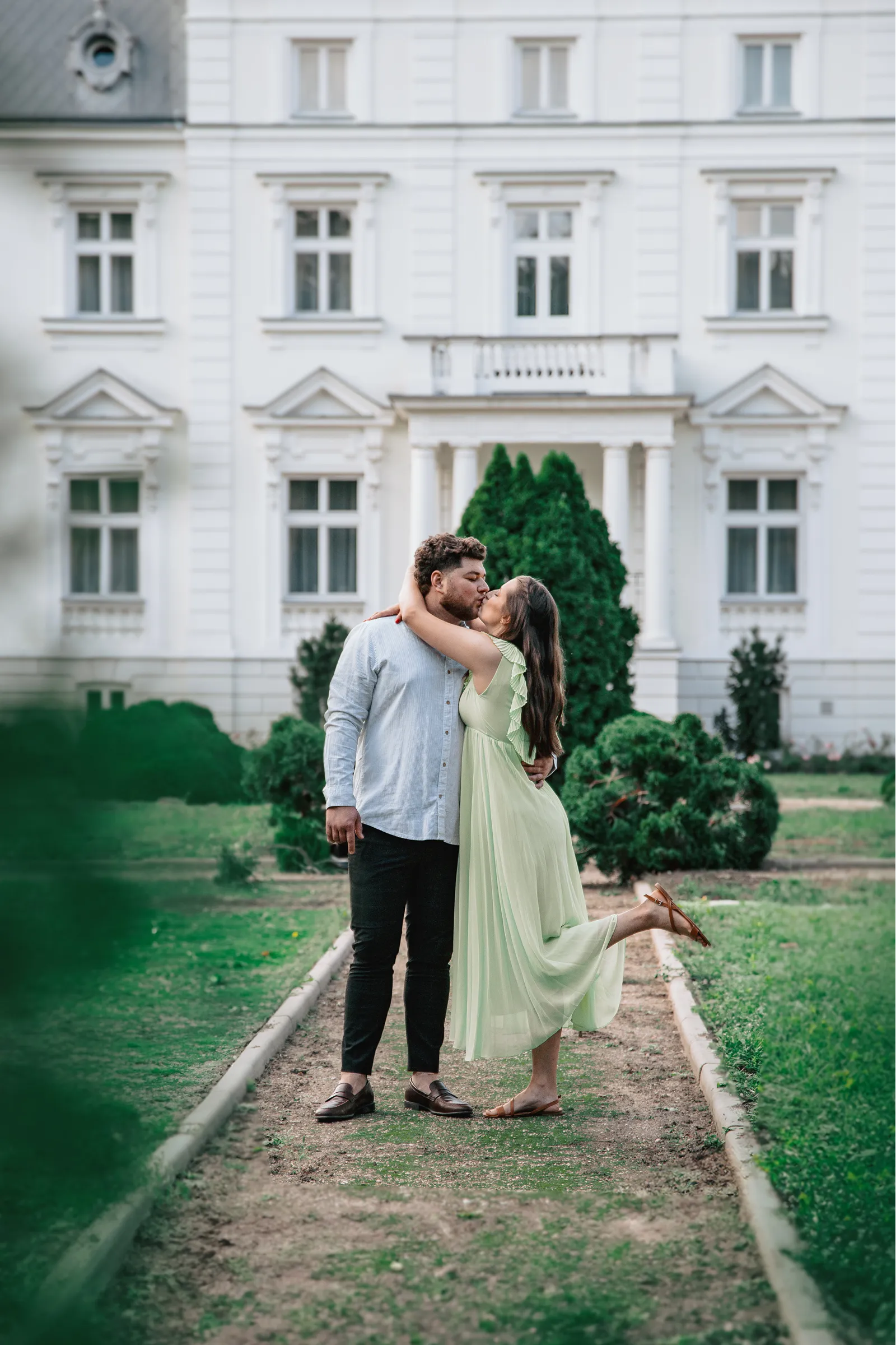 Romantyczny pocałunek pary przed pałacem - plenerowa sesja dla par Nowy Dwór Mazowiecki