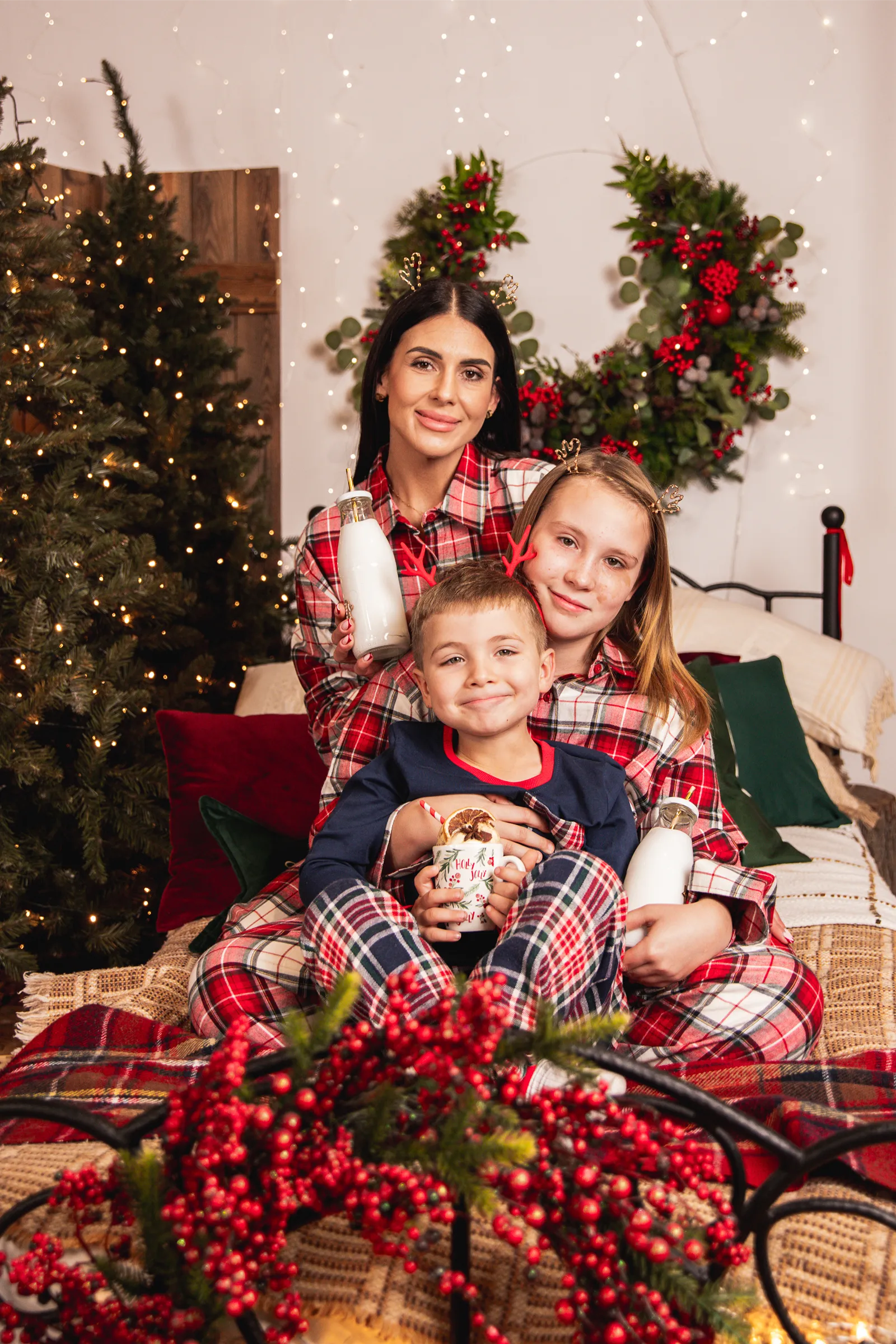 Mama z dziećmi relaksująca się na łóżku w studio fotograficznym Legionowo