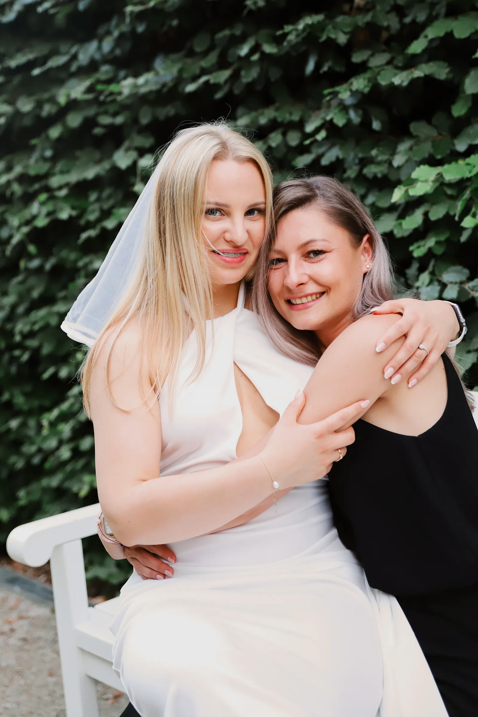 Przyjaciółki przytulające się na ławeczce w parku - sesja panieńska Legionowo