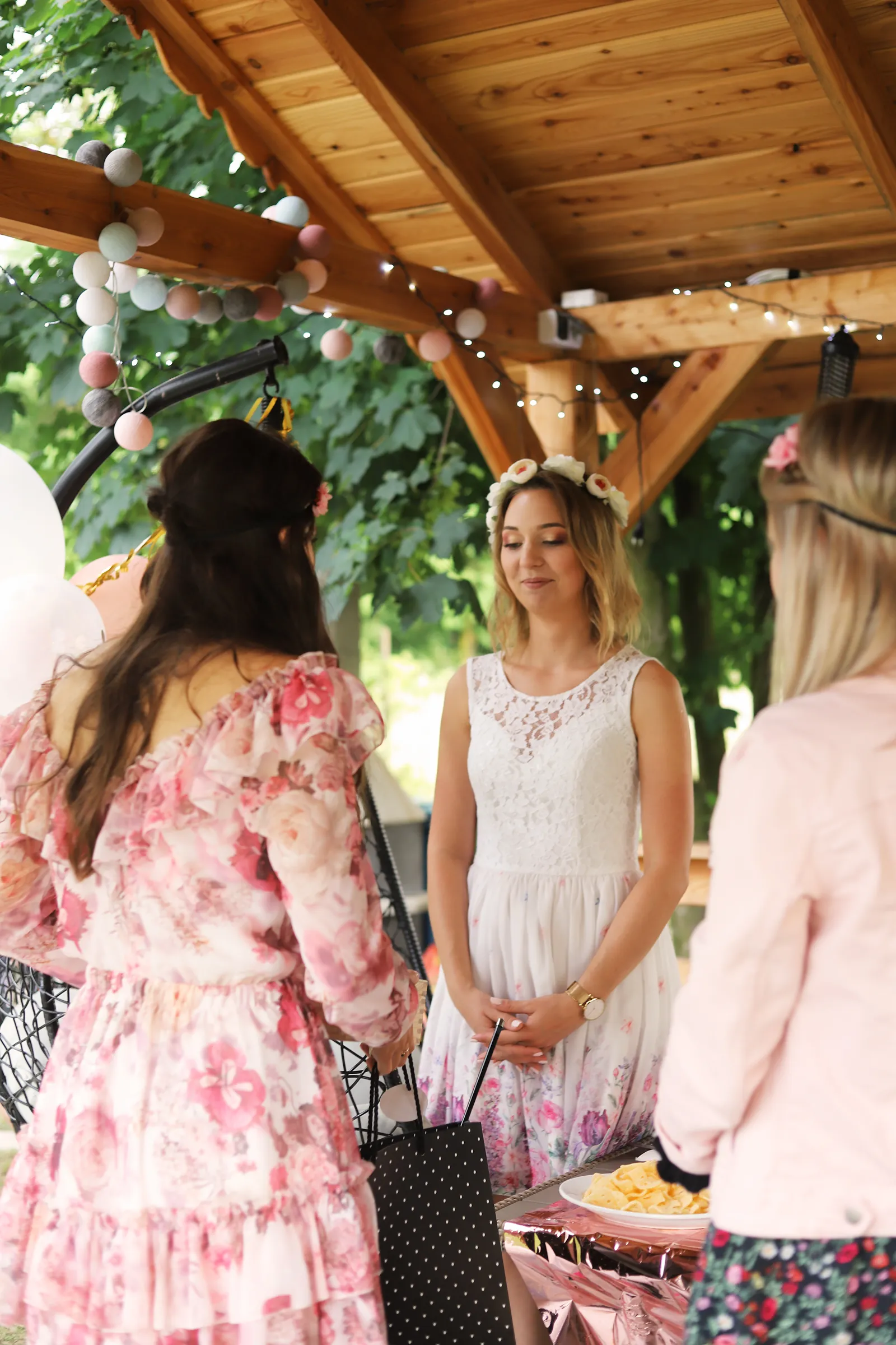 Dziewczyny rozmawiające i śmiejące się pod drewnianą altaną